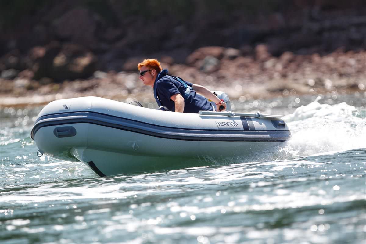 Rigid inflatable boat with Honda engine and one guy driving
